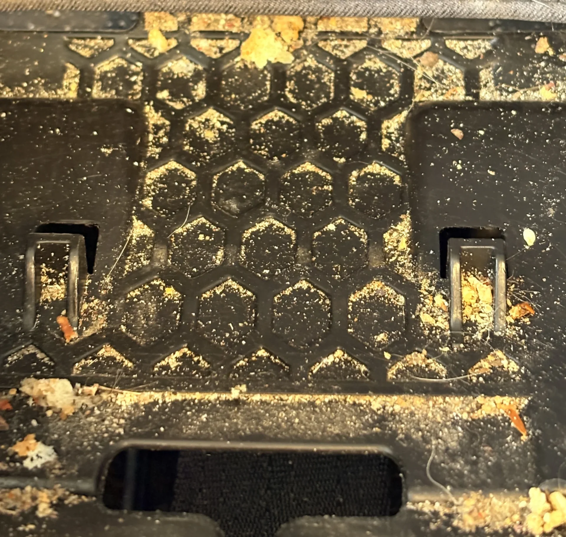 Dirty car seat crumb tray before cleaning